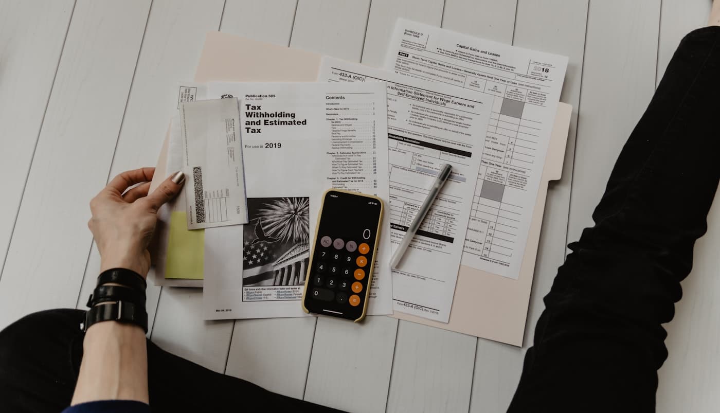 Calculator, glasses, and financial documents on a workspace desk